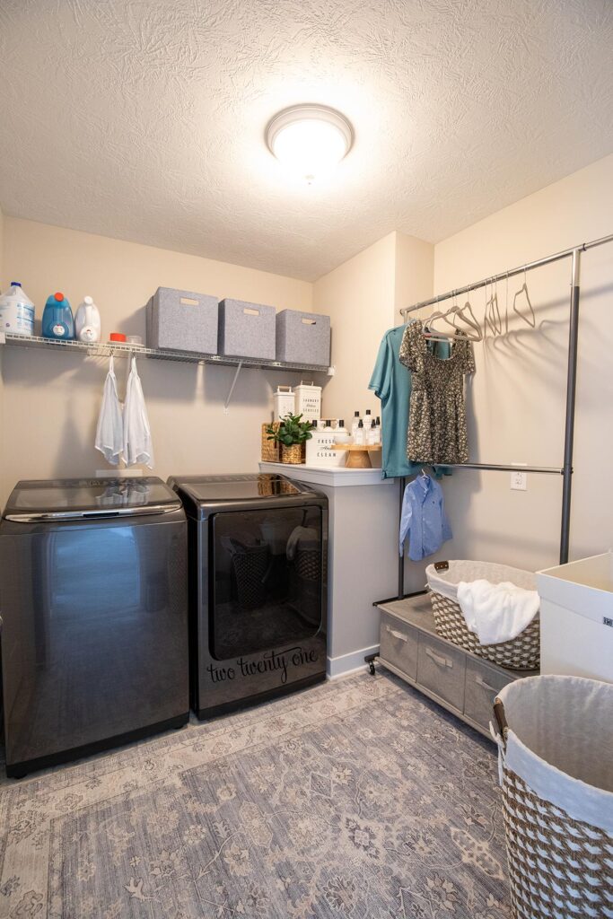 laundry room with washer and dryer, garment rack, bins, and hampers
